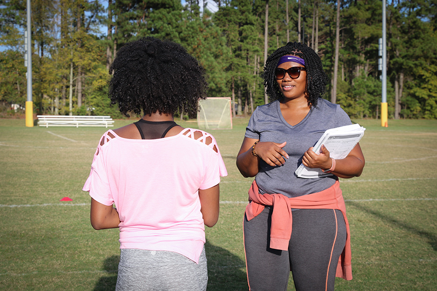 Two Girls on the Run coaches smiling as they read lesson